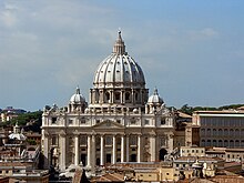 Photo. The façade is wide and has a row of huge columns rising from the basement to support the cornice. The ribbed, ovoid dome is surmounted by a lantern topped with ball and cross. Its drum is framed by two very much smaller domes.