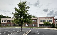 A multi-story set of beige and brick buildings