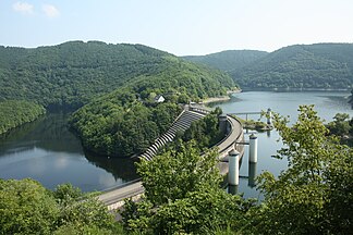 Blick vom Südwestende der Urftstaumauer zum Kermeter hinten links; im Vordergrund links der Obersee (Vorsperre der Rurtalsperre) mit Staumauer-Überlauf der Urfttalsperre