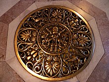 White and orange marble rings a circular, decorated bronze vent