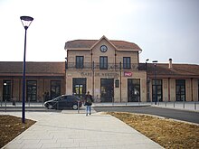 Bâtiment en pierre avec deux ailes et un parvis devant.