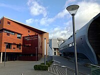 Two modern buildings, one brick and the other curved