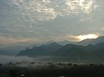 Sunset or sunrise over a mountain landscape with fog in the valleys.