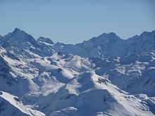 Panorama sur des montagnes enneigées sous un ciel sans nuage.