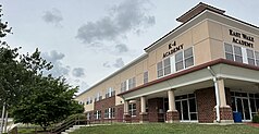 A multi-story set of beige and brick buildings