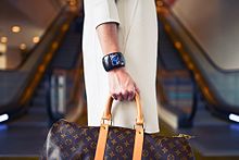 Woman wearing jewelry and carrying designer shopping bag