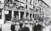 Japanske tropper går ind i Hongkong og marcherer på Queen's Road, under ledelse af generalløjtnant Takashi Sakai og viceadmiral Masaichi Niimi i december 1941, efter den britiske overgivelse.