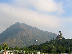 Az óriás Buddha-szobor, háttérben a Lánthau (Lantau)-csúcs