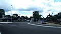 Le centre commercial avec son bureau de poste communal. Au fond le château de Choisy et devant la sculpture du Pèlerin de Saint-Jacques de Compostelle.