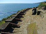 Defensive coastal wall with several old-style cannons