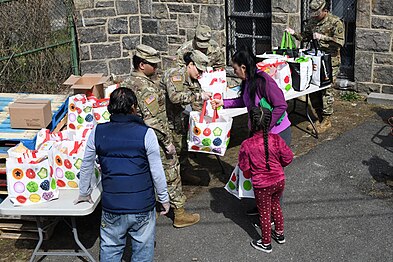 New York National Guard soldiers hand groceries to members of the community at a food distribution point at Hope Community Services in New Rochelle, United States