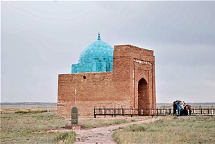 A large brick building with a round bright blue dome.