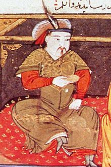 Painting of a turbaned man sitting cross-legged on a carpet