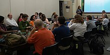 People at a long table with laptop computers