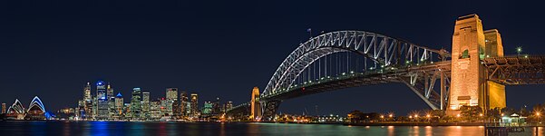 Panorámakép a Port Jakson városrészről, előtérben balra az Operaház, az üzleti negyed középen, és jobbra a Sydney Harbour Bridge