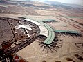 Tilted aerial view of modern airport. Aircraft are parked next to "arms" that extend from the central building (from Transport)