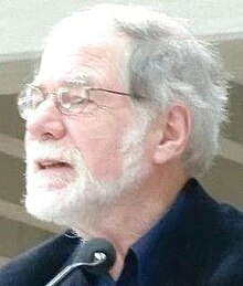 Profile of man with white hair, beard and spectacles