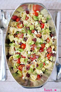 a salad with tomatoes, cucumbers, olives and feta cheese in a serving dish