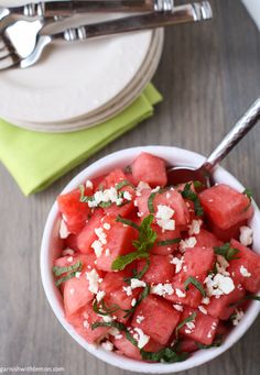 watermelon salad with feta cheese and mint in a white bowl on a wooden table