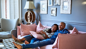 A couple sitting on the couch, streaming TV.