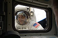 Mission Specialist Michael Massimino peers into the orbiter's aft flight deck window, during the fourth spacewalk of the mission.