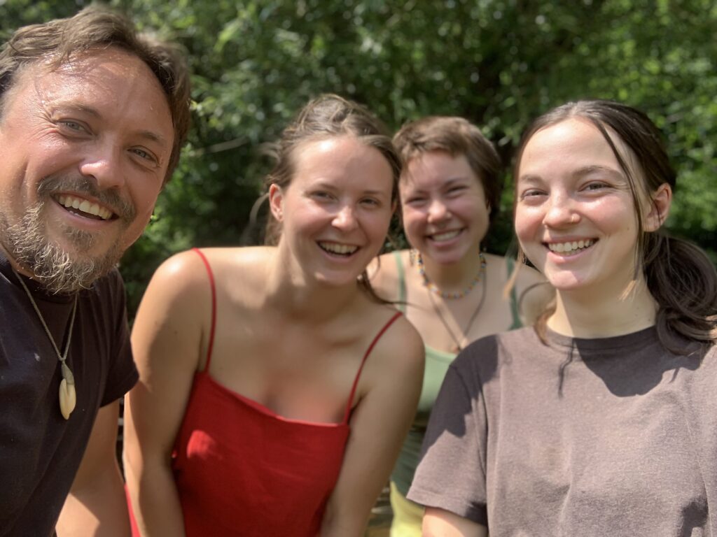 3 women and a man smiling at the camera.