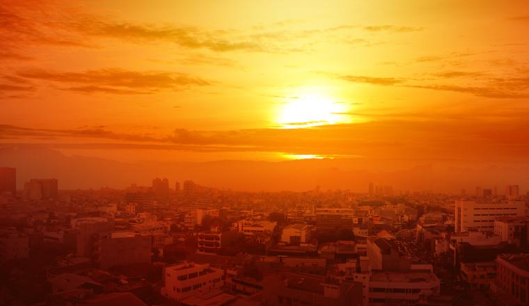 Heatwave on the city with the glowing sun background