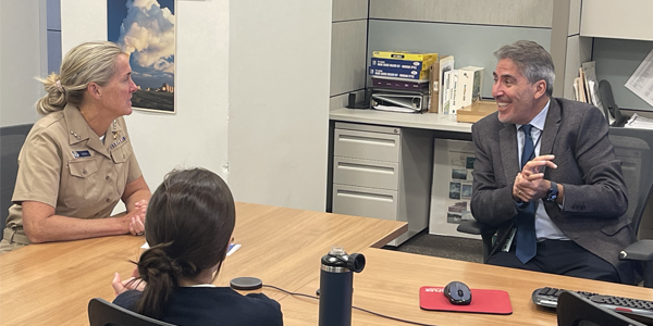 Two women and a man talking around a conference table