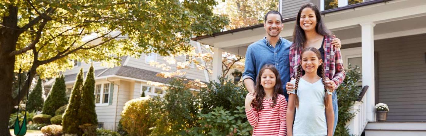 Family standing in front of home