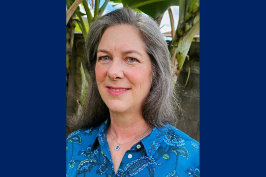 Headshot of Sarah Malloy smiling with dark blue background