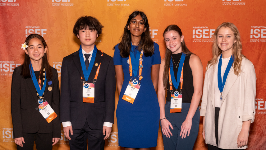 Five smiling high school students wearing blue NOAA award medals standing in front of an orange background. 