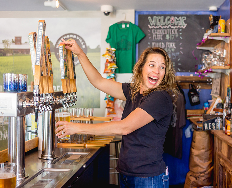 a person pouring beer from tap